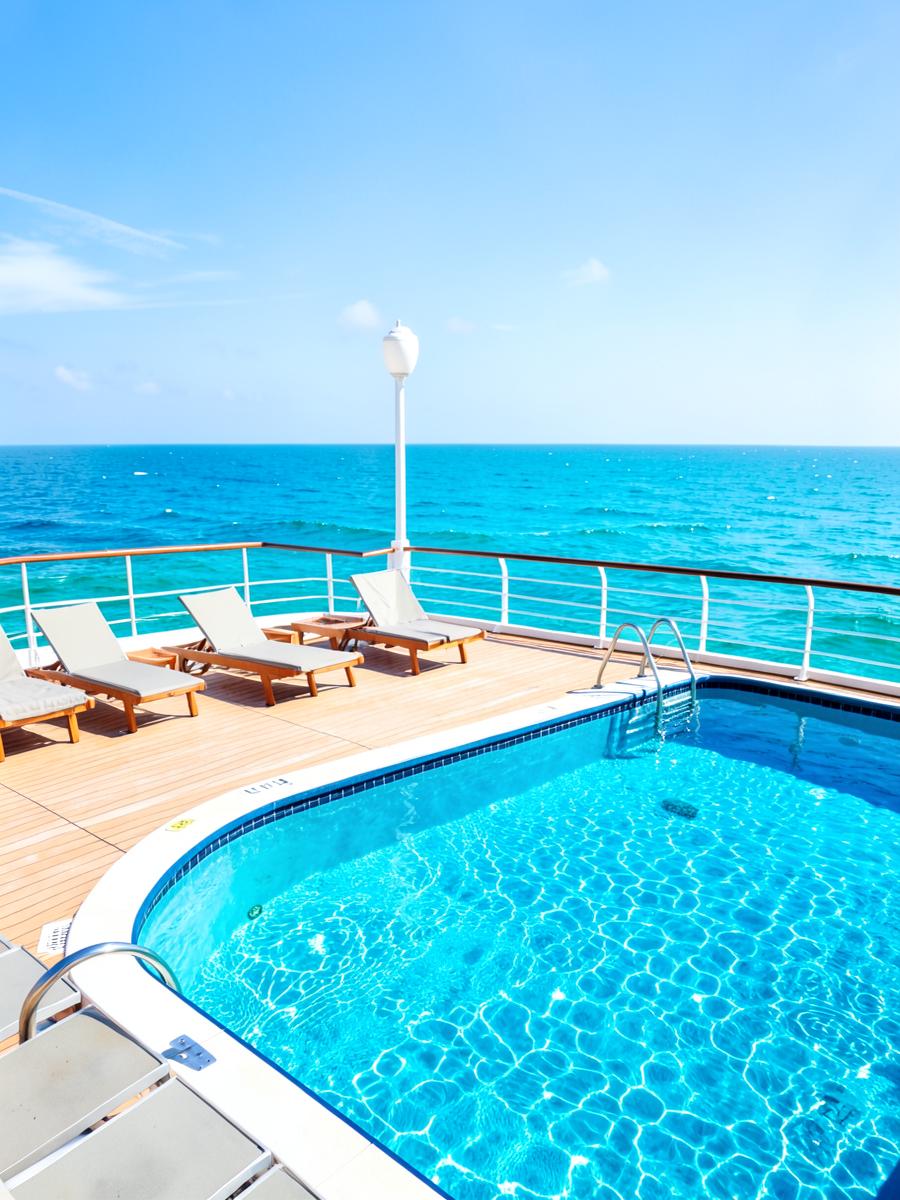 Sunny cruise ship pool deck overlooking turquoise ocean